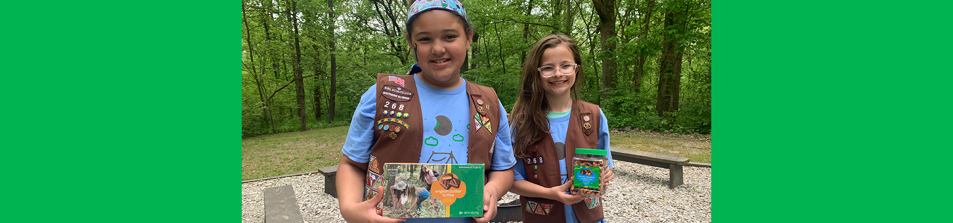  two girl scouts holding fall nut and candy products 